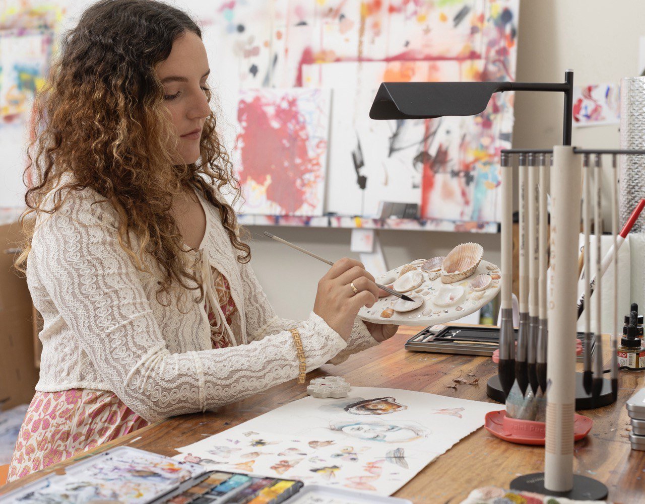 Dimitra creating artwork at her studio table